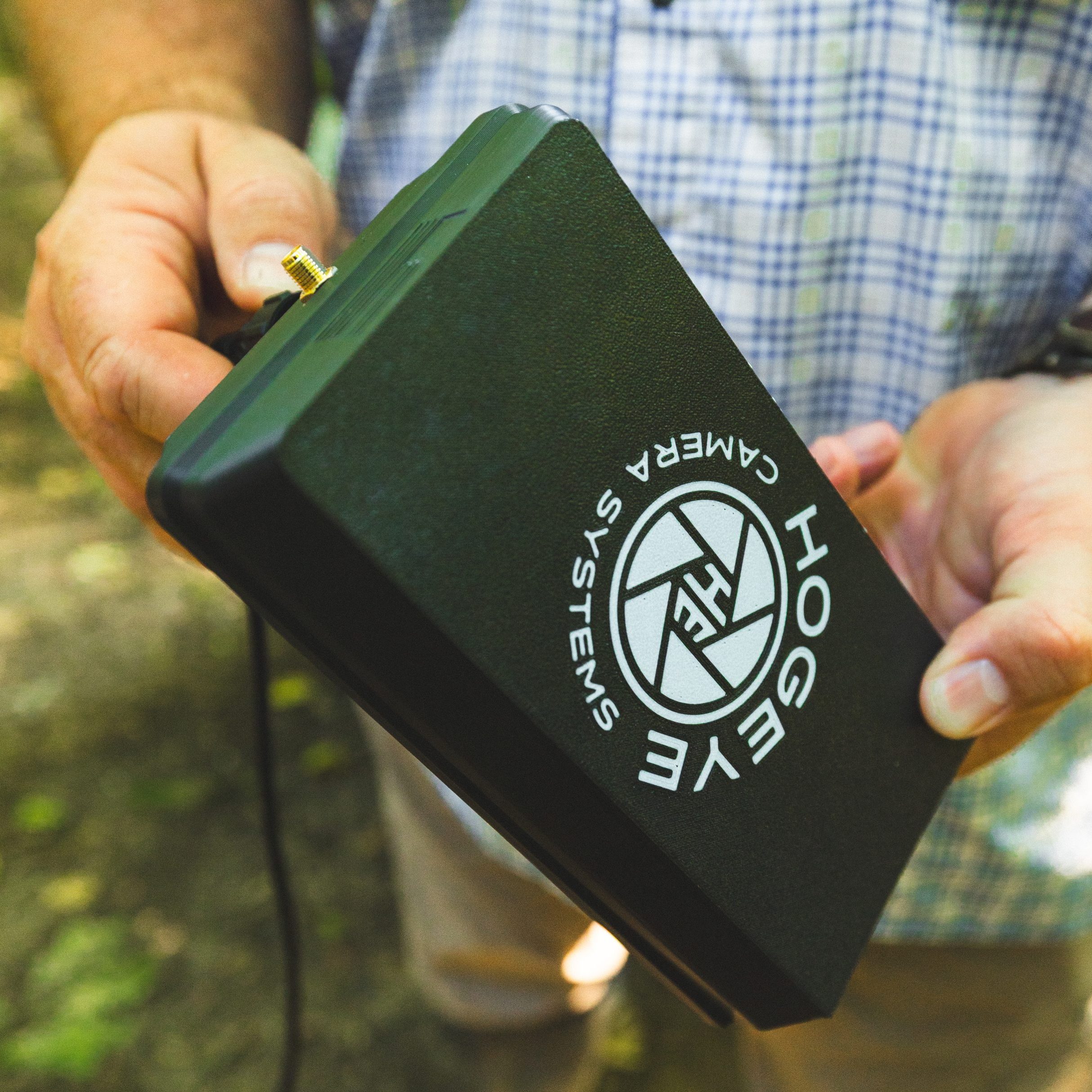 remote triggering HogEye camera branding on a black device being held